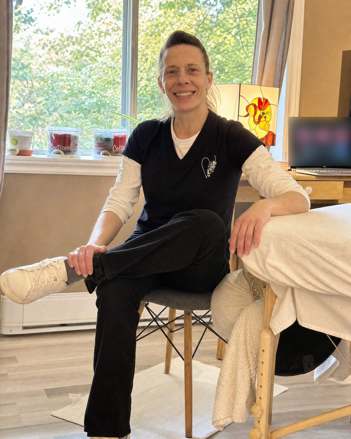 Geneviève Fafard assise près de la table de massage dans son cabinet de Saint-Jérôme